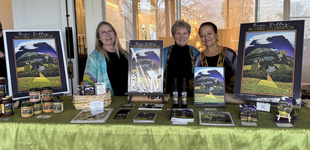 Heather Hamilton, Jessel Miller and Nouria Harris stand with copies of this year's poster art at the sold-out Jan. 17 launch of the 2026 Mustard Celebration held at Silverado Resort. Submitted photo