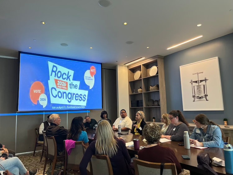 group of people in a room face a panel of speakers